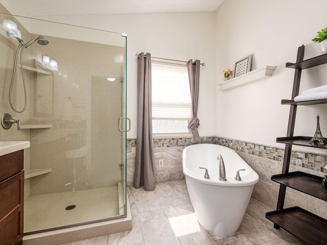 824 Lynnfield Dr, Westerville, OH 43081 - bathroom featuring a stall shower, tile walls, a freestanding tub, vanity, and a wainscoted wall