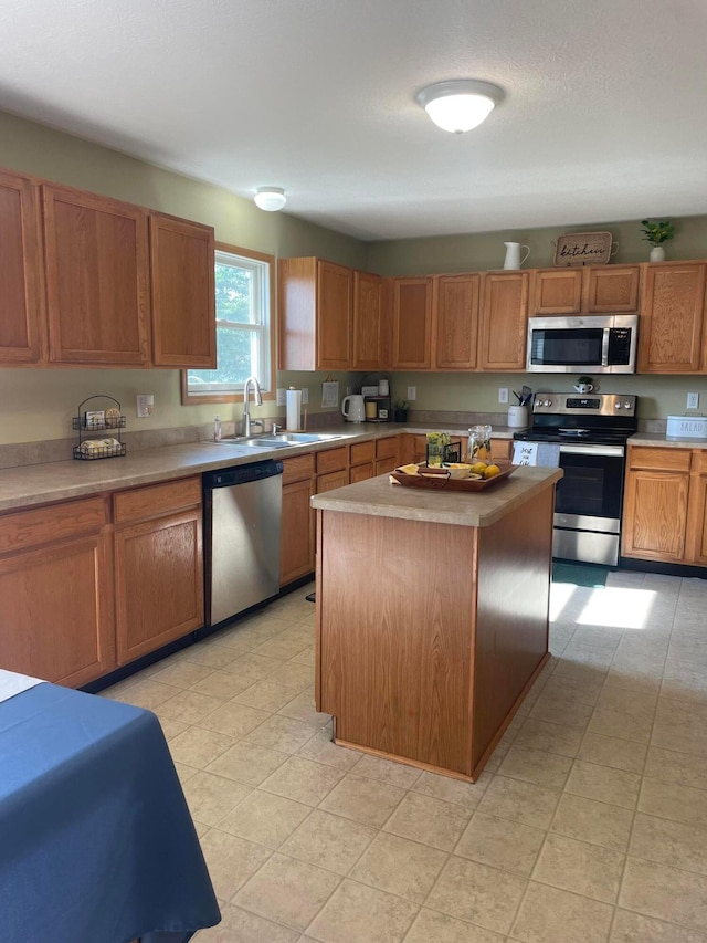 1889 Salt Lick Dr, Lancaster, OH 43130 - kitchen with appliances with stainless steel finishes, a kitchen island, brown cabinetry, and light countertops