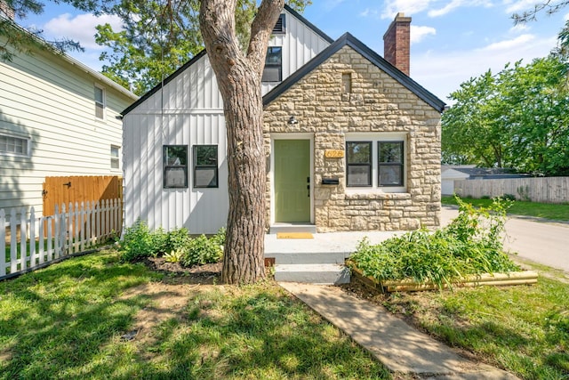 628 E Gates St, Columbus, OH 43206 - view of front facade featuring board and batten siding, stone siding, and a chimney
