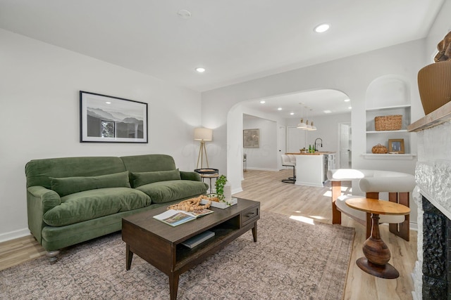 628 E Gates St, Columbus, OH 43206 - living area featuring arched walkways, light wood finished floors, recessed lighting, and a fireplace