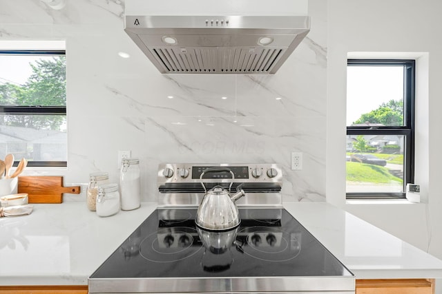628 E Gates St, Columbus, OH 43206 - kitchen view of stainless steel electric range, wall chimney range hood, decorative backsplash, and light countertops
