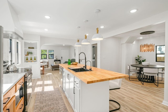 628 E Gates St, Columbus, OH 43206 - kitchen featuring appliances with stainless steel finishes, butcher block counters, light wood-type flooring, a kitchen breakfast bar, and arched walkways