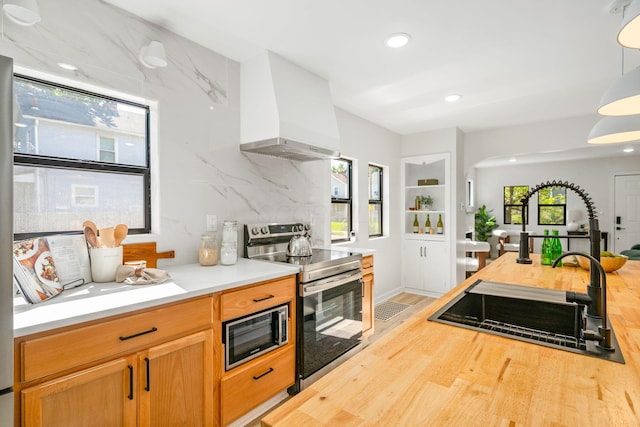 628 E Gates St, Columbus, OH 43206 - kitchen with stainless steel appliances, butcher block countertops, custom exhaust hood, wood finished floors, and recessed lighting