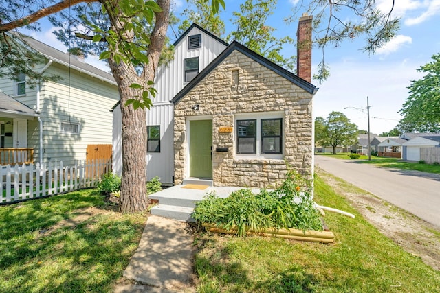 628 E Gates St, Columbus, OH 43206 - view of front facade with board and batten siding, stone siding, and a chimney
