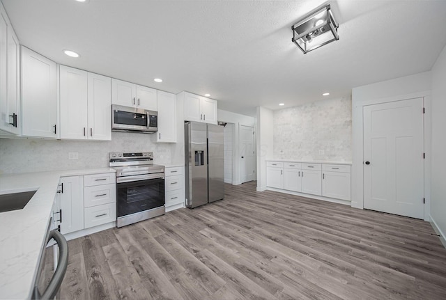 368 Woodview Dr, Chillicothe, OH 45601 - kitchen featuring stainless steel appliances, light wood-style floors, white cabinetry, decorative backsplash, and recessed lighting