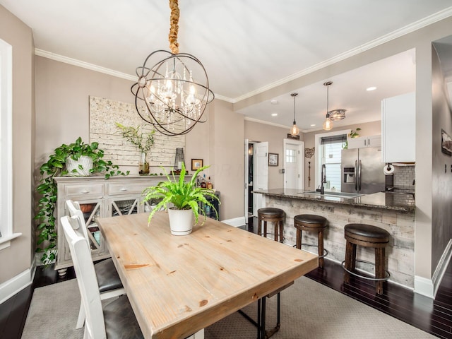 624 Oakwood Ave, Columbus, OH 43205 - dining space with dark wood finished floors, ornamental molding, a chandelier, and recessed lighting