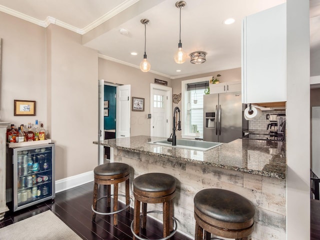 624 Oakwood Ave, Columbus, OH 43205 - kitchen with stainless steel fridge, white cabinetry, a peninsula, dark stone countertops, and dark wood-type flooring