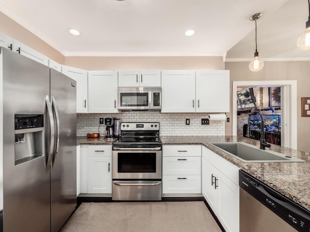 624 Oakwood Ave, Columbus, OH 43205 - kitchen featuring stainless steel appliances, crown molding, tasteful backsplash, white cabinets, and decorative light fixtures