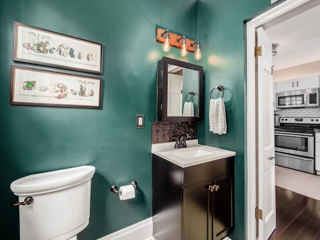 624 Oakwood Ave, Columbus, OH 43205 - bathroom featuring decorative backsplash, vanity, and wood finished floors