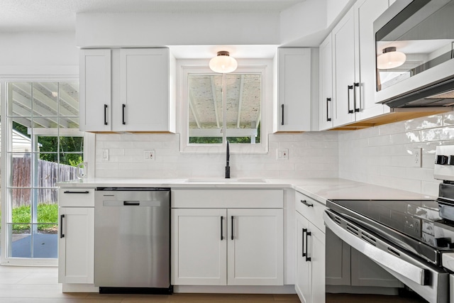 3048 Wallingford Ave, Columbus, OH 43231 - kitchen featuring stainless steel appliances, white cabinets, decorative backsplash, and light countertops
