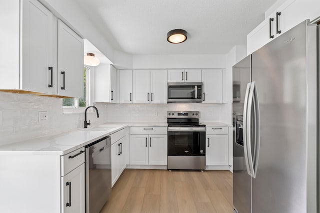 3048 Wallingford Ave, Columbus, OH 43231 - kitchen with stainless steel appliances, light wood-style floors, white cabinets, and light stone counters