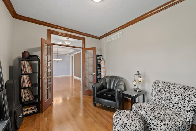 6820 Mahogany Dr, Galena, OH 43021 - sitting room with ornamental molding, wood finished floors, french doors, and a chandelier