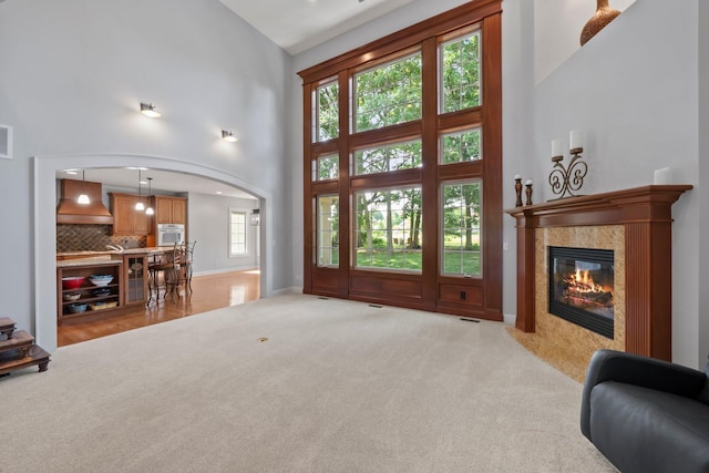 6820 Mahogany Dr, Galena, OH 43021 - living area with light carpet, high vaulted ceiling, a fireplace, and arched walkways