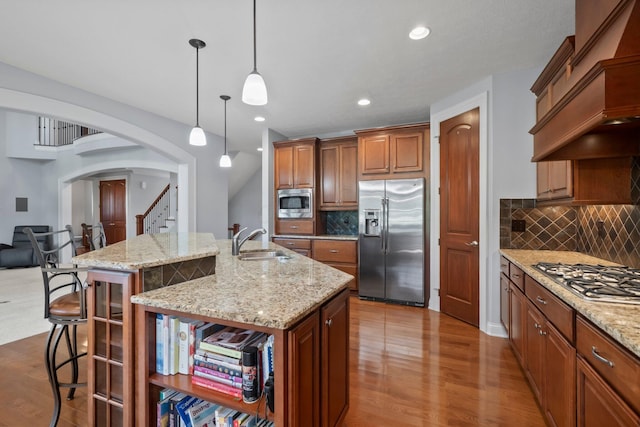 6820 Mahogany Dr, Galena, OH 43021 - kitchen with appliances with stainless steel finishes, custom exhaust hood, a center island with sink, arched walkways, and a kitchen bar
