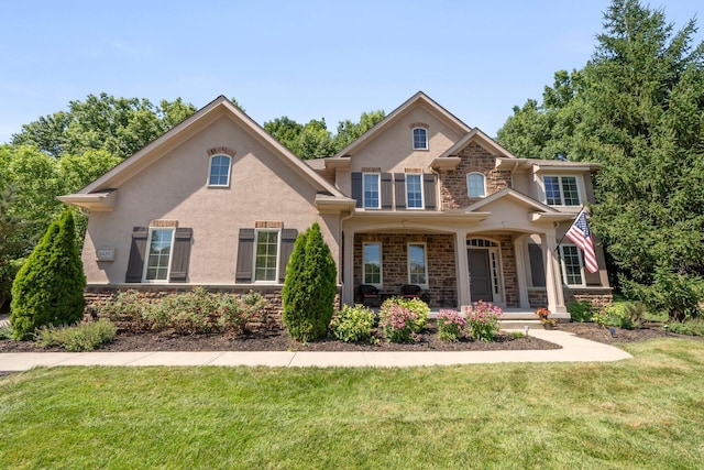 6820 Mahogany Dr, Galena, OH 43021 - view of front of house with stone siding, stucco siding, a front yard, and covered porch
