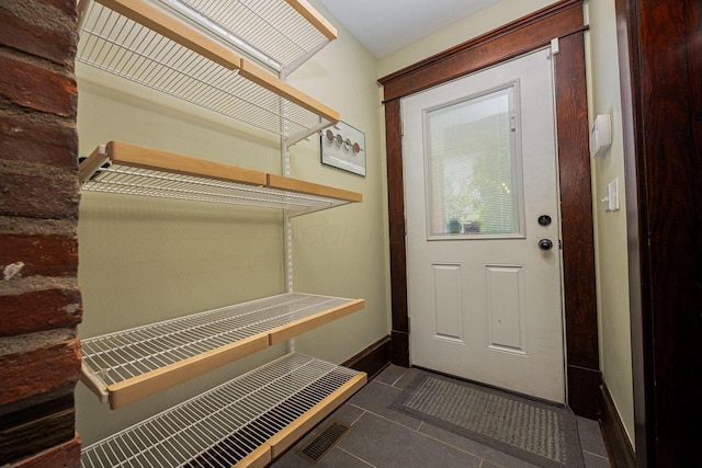 199 E Gates St, Columbus, OH 43206 - doorway to outside featuring dark tile patterned flooring and baseboards