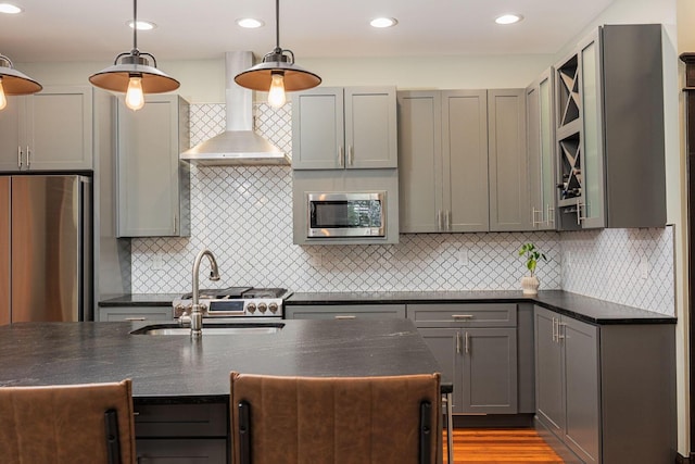 199 E Gates St, Columbus, OH 43206 - kitchen with stainless steel appliances, wall chimney exhaust hood, tasteful backsplash, hanging light fixtures, and gray cabinetry