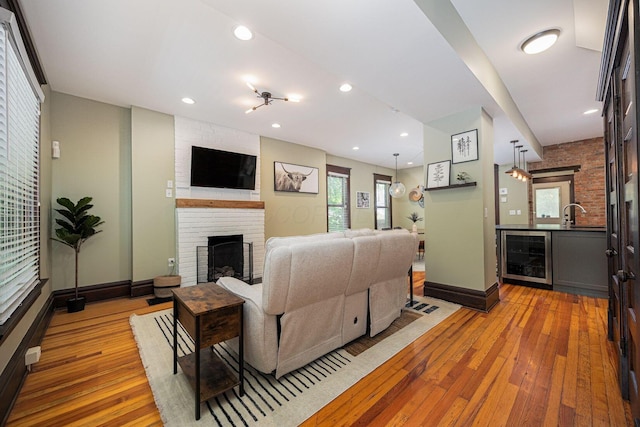 199 E Gates St, Columbus, OH 43206 - living area featuring beverage cooler, light wood-style floors, a brick fireplace, and recessed lighting