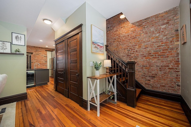 199 E Gates St, Columbus, OH 43206 - hallway featuring wine cooler, hardwood / wood-style flooring, brick wall, and stairs