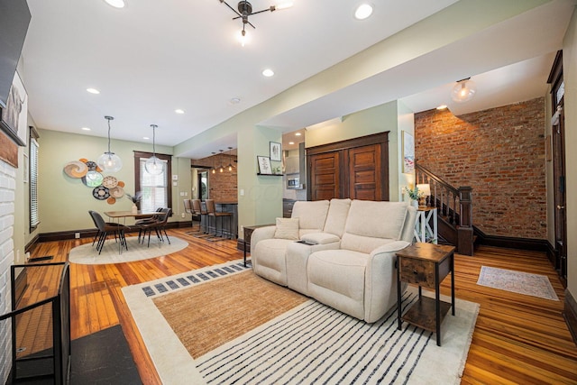 199 E Gates St, Columbus, OH 43206 - living room with wood finished floors, brick wall, a fireplace, and recessed lighting