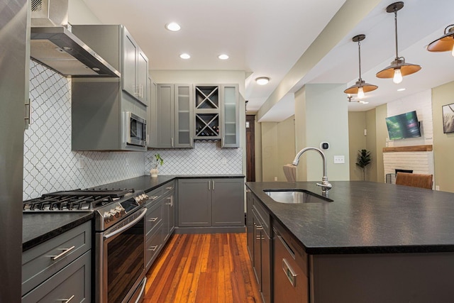 199 E Gates St, Columbus, OH 43206 - kitchen with appliances with stainless steel finishes, wall chimney range hood, dark wood-style floors, backsplash, and glass insert cabinets