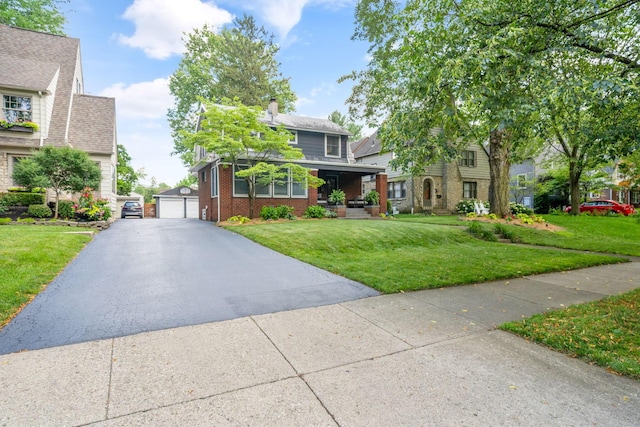 70 N Cassingham Rd, Columbus, OH 43209 - view of front of house featuring brick siding, a front lawn, an outbuilding, a chimney, and a garage