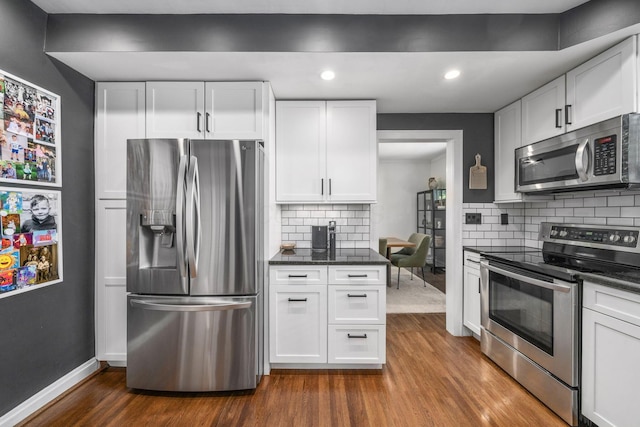 70 N Cassingham Rd, Columbus, OH 43209 - kitchen with appliances with stainless steel finishes, dark wood-type flooring, white cabinets, decorative backsplash, and recessed lighting