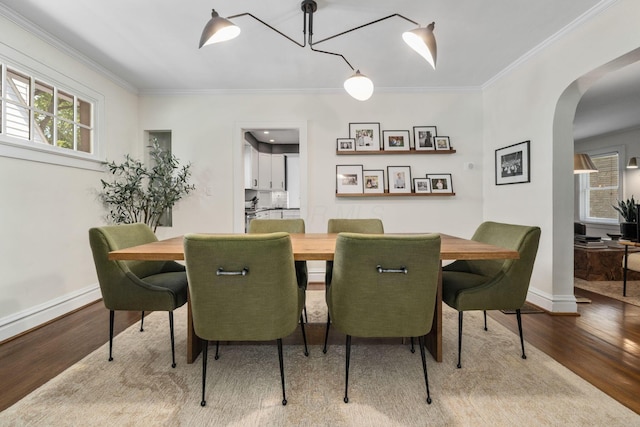 70 N Cassingham Rd, Columbus, OH 43209 - dining area featuring arched walkways, plenty of natural light, wood finished floors, and ornamental molding
