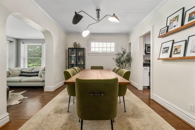 70 N Cassingham Rd, Columbus, OH 43209 - dining area with healthy amount of natural light, crown molding, arched walkways, and dark wood-type flooring
