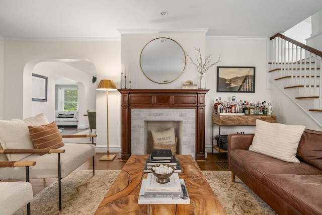 70 N Cassingham Rd, Columbus, OH 43209 - living room featuring ornamental molding, arched walkways, stairs, wood finished floors, and a dry bar