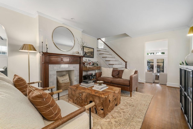 70 N Cassingham Rd, Columbus, OH 43209 - living room with crown molding, stairway, light wood-type flooring, and a tiled fireplace