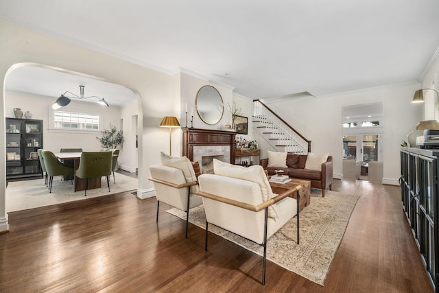 70 N Cassingham Rd, Columbus, OH 43209 - living area with a tile fireplace, stairway, dark wood-type flooring, arched walkways, and ornamental molding