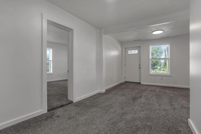 8898 Baker Rd, Stoutsville, OH 43154 - foyer featuring dark carpet and a textured ceiling