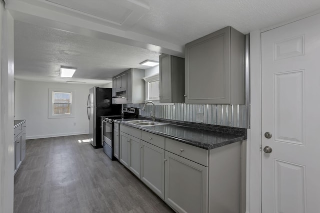 8898 Baker Rd, Stoutsville, OH 43154 - kitchen featuring stainless steel appliances, a textured ceiling, dark wood-style flooring, dark countertops, and gray cabinets