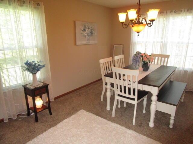 5669 Maplewood Ct, Lewis Center, OH 43035 - carpeted dining area with a chandelier and baseboards