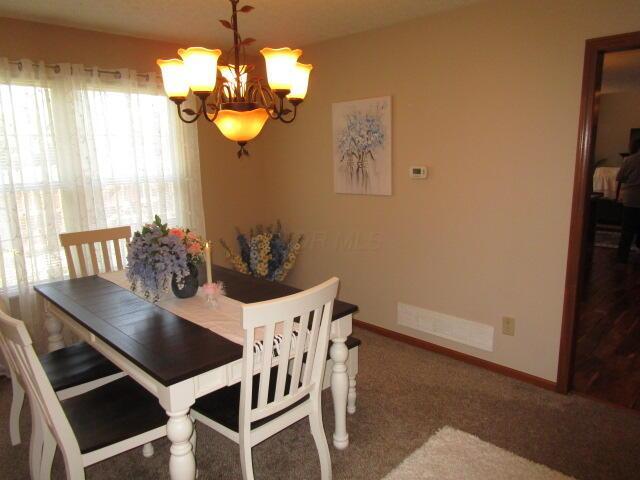 5669 Maplewood Ct, Lewis Center, OH 43035 - carpeted dining area with a chandelier and baseboards