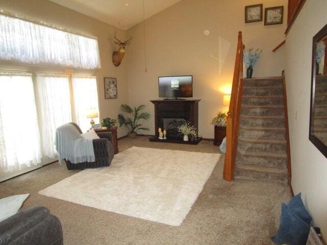 5669 Maplewood Ct, Lewis Center, OH 43035 - carpeted living area with stairs, vaulted ceiling, and a fireplace