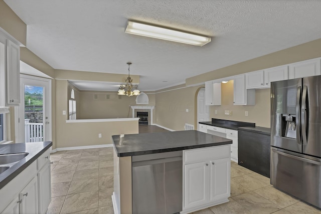 3902 Rivers Run Dr, Lewis Center, OH 43035 - kitchen with stainless steel fridge, dark countertops, a fireplace, white cabinetry, and a chandelier