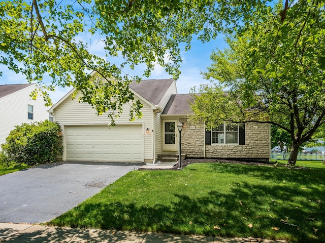 419 Sycamore Creek St, Pickerington, OH 43147 - view of front of home with an attached garage, asphalt driveway, stone siding, and roof with shingles