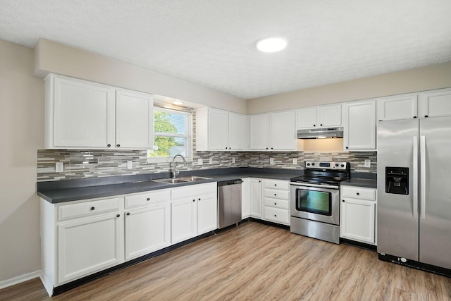 1771 Fern Trail Dr, Lancaster, OH 43130 - kitchen featuring appliances with stainless steel finishes, under cabinet range hood, dark countertops, light wood-type flooring, and white cabinets