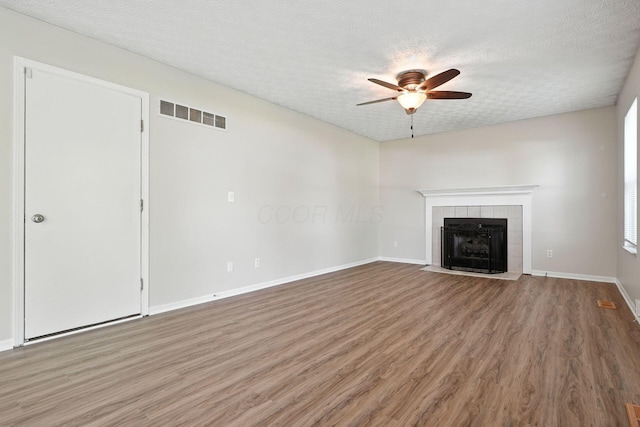 1771 Fern Trail Dr, Lancaster, OH 43130 - unfurnished living room with a ceiling fan, a tile fireplace, wood finished floors, and a textured ceiling