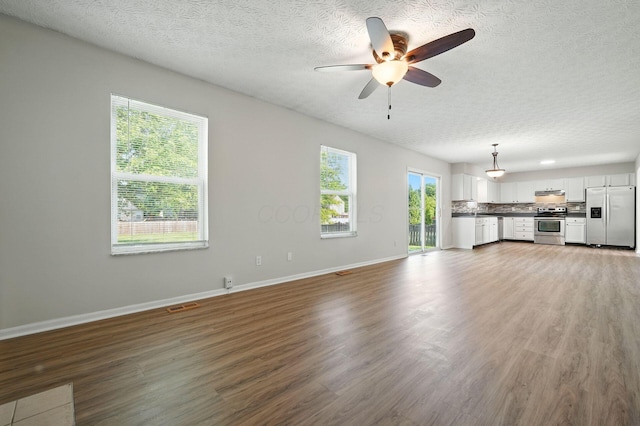 1771 Fern Trail Dr, Lancaster, OH 43130 - unfurnished living room with a textured ceiling, wood finished floors, and a ceiling fan