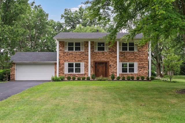 6853 Cedar Brook Pl, New Albany, OH 43054 - view of front of home with asphalt driveway, an attached garage, a front yard, and brick siding