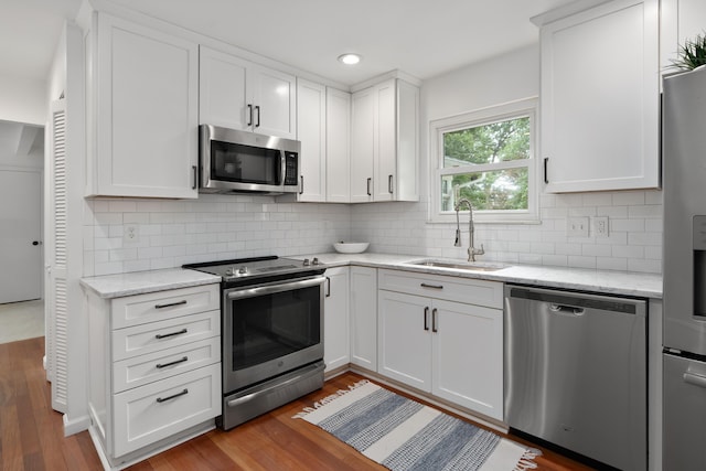 6853 Cedar Brook Pl, New Albany, OH 43054 - kitchen featuring stainless steel appliances, wood finished floors, tasteful backsplash, white cabinetry, and recessed lighting