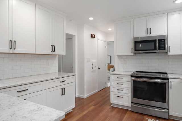 6853 Cedar Brook Pl, New Albany, OH 43054 - kitchen with stainless steel appliances, wood finished floors, white cabinetry, tasteful backsplash, and recessed lighting
