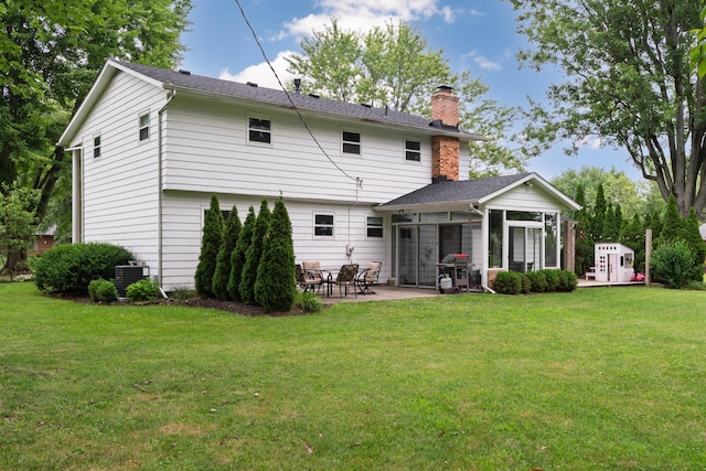 6853 Cedar Brook Pl, New Albany, OH 43054 - rear view of house with a chimney, a patio, a sunroom, and a yard