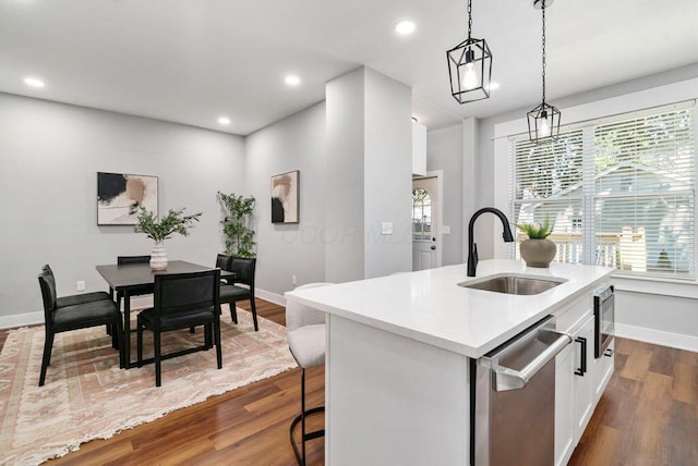 994 Harrison Ave, Columbus, OH 43201 - kitchen featuring stainless steel dishwasher, a center island with sink, dark wood-type flooring, light countertops, and plenty of natural light