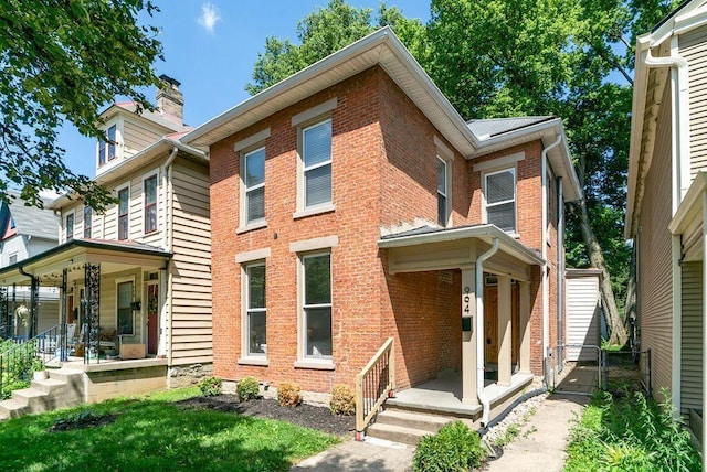 994 Harrison Ave, Columbus, OH 43201 - back of property with covered porch, brick siding, a chimney, and a gate