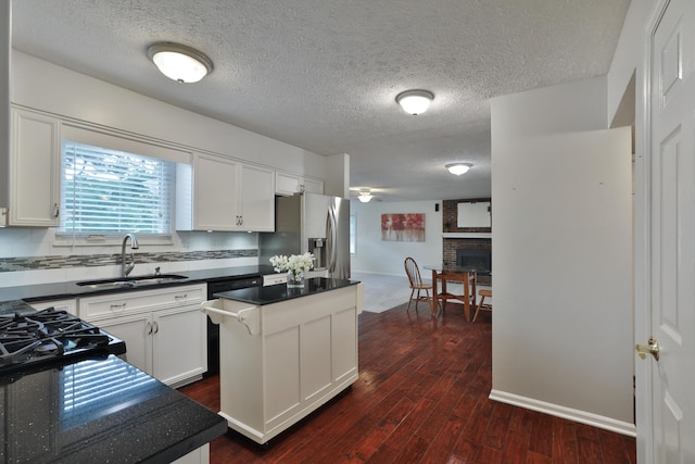 2253 Otter Ln, Dublin, OH 43016 - kitchen with stainless steel refrigerator with ice dispenser, dark countertops, dark wood-style flooring, a textured ceiling, and a center island