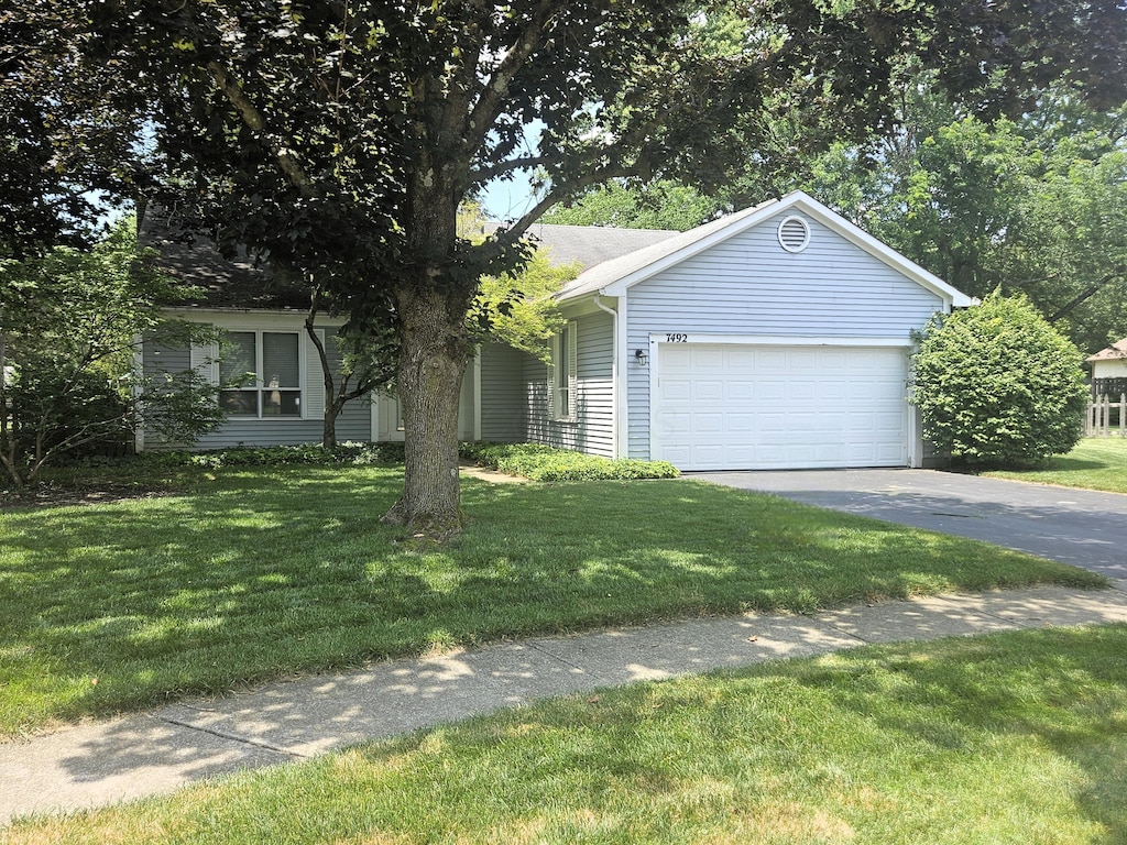 7492 Sagewood Ct, Columbus, OH 43235 - view of front of property featuring asphalt driveway, a garage, and a front yard